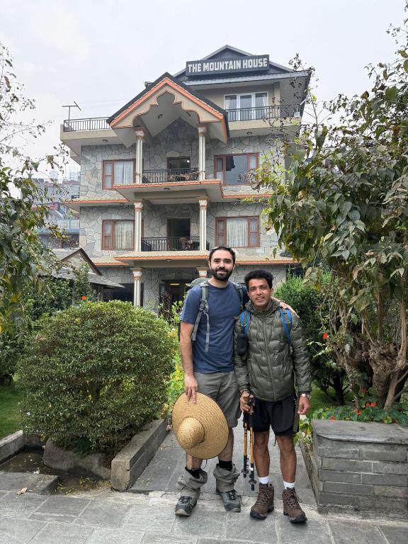 Due uomini sono in piedi davanti a un edificio di The Mountain House a Pokhara