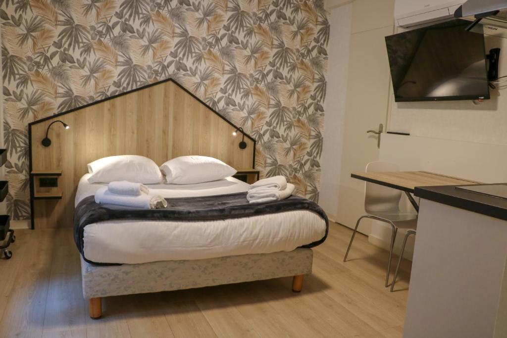 une chambre avec un lit avec une tête de lit en bois dans l'établissement Revotel - Studio & Chambre - Semaine & Mois, à Aix-les-Bains