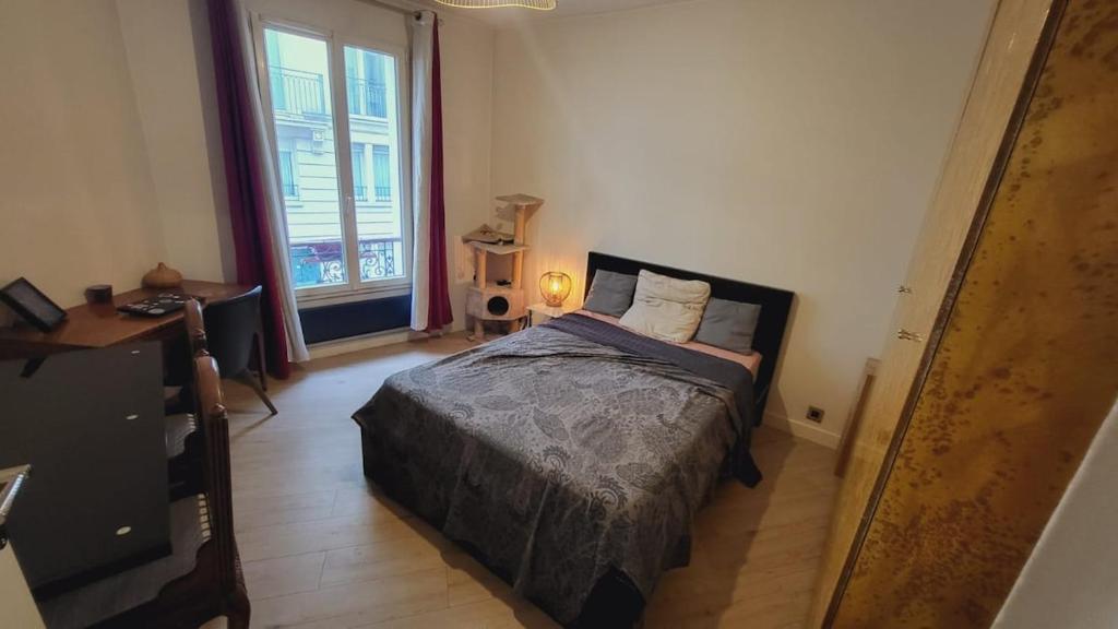 a bedroom with a bed and a large window at Beautiful 3-room, Porte Saint-Cloud, Paris in Paris