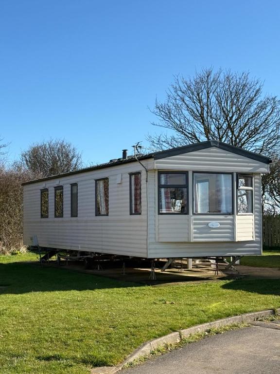 a tiny house is sitting on the grass at Daisy Lodge Lilac Grove 3 in Waxholme