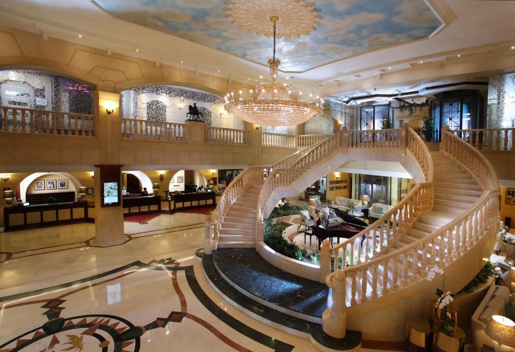 a large lobby with stairs and a chandelier at Carlton Palace Hotel in Dubai