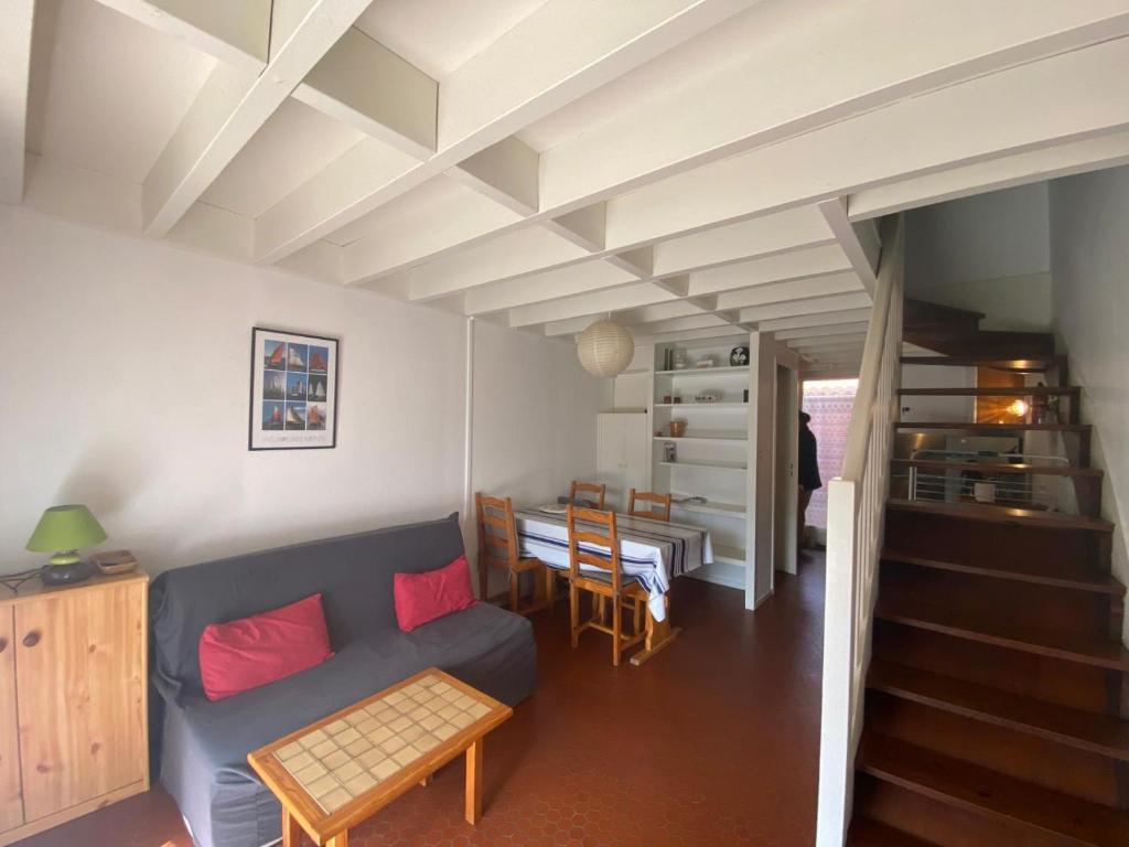 un salon avec un canapé bleu et une table dans l'établissement Villa patio proche du port, à Capbreton