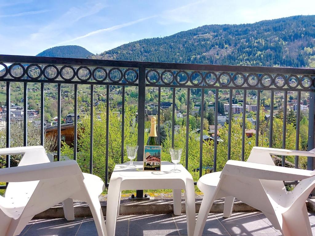une table blanche et des chaises sur un balcon avec vue dans l'établissement Apartment Les erables by Interhome, à Saint-Gervais-les-Bains