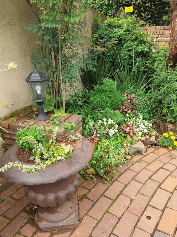a garden with a stone bench and flowers at 125 on Van Buuren Road Guest House in Johannesburg