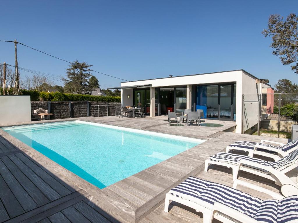 a swimming pool with chairs and a house at Holiday Home Villa de la Baie by Interhome in Locquirec