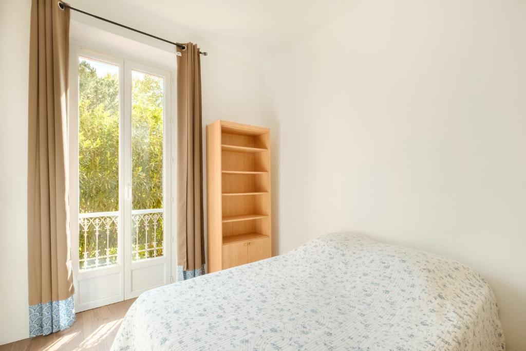 une chambre avec un lit et une fenêtre dans l'établissement Le Villeneuve Village, à Villeneuve-Loubet