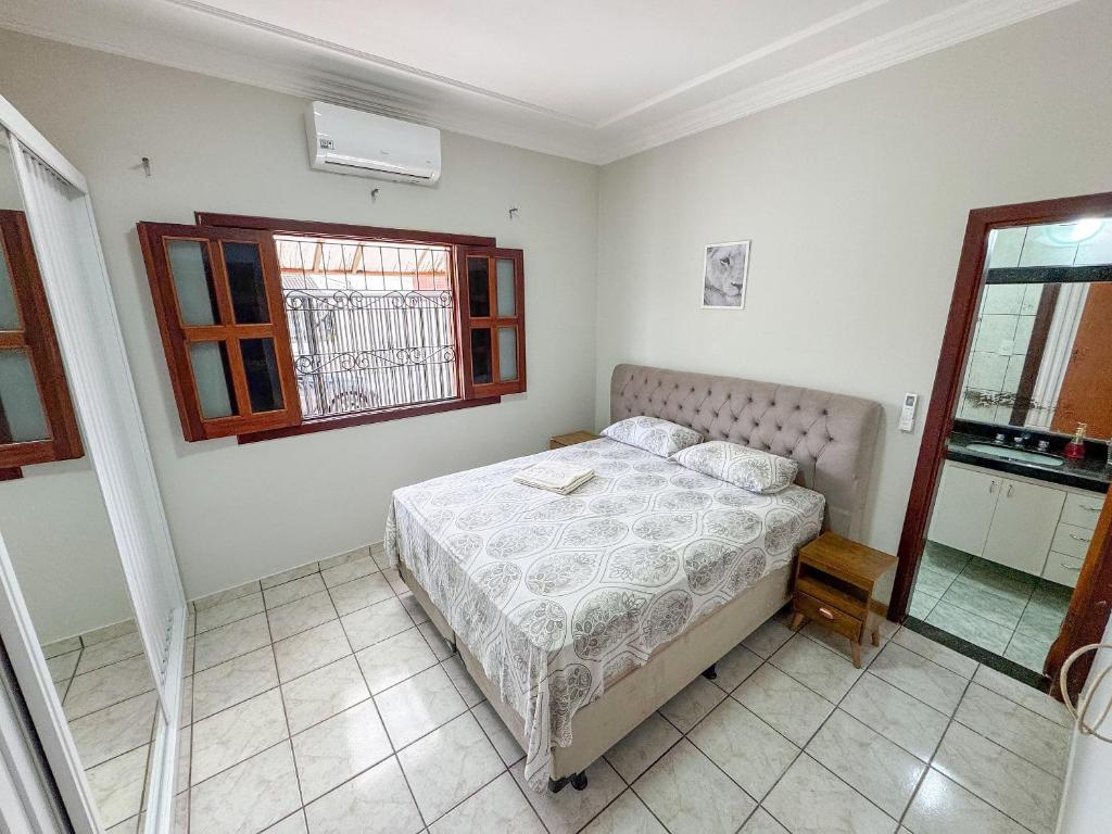 a bedroom with a bed and a window at Casa p/ 11 hóspedes - 900m do Parque de Exposições in Patos de Minas