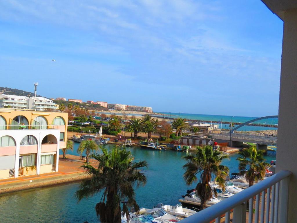 une vue sur une rivière avec des palmiers sur un balcon dans l'établissement Charmant T2 à Sète avec Loggia et Parking - FR-1-472-123, à Sète