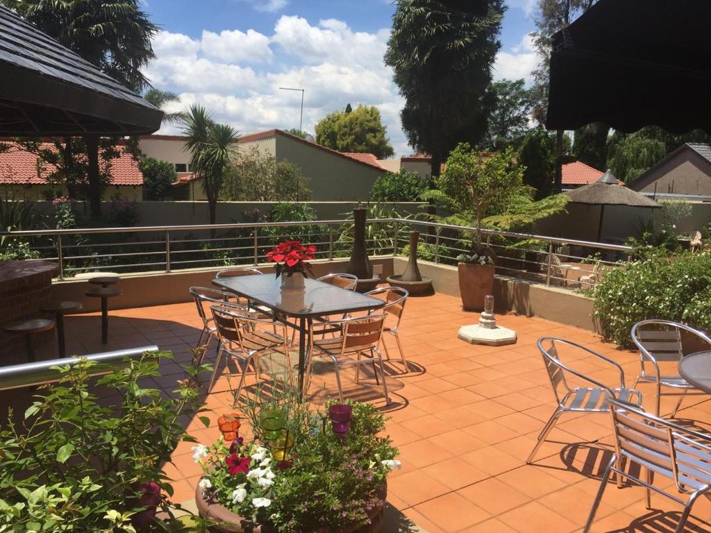 a patio with a table and chairs and flowers at 125 on Van Buuren Road Guest House in Johannesburg