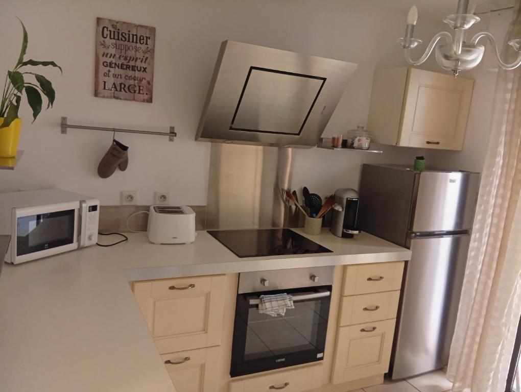 une cuisine avec un réfrigérateur et un micro-ondes dans l'établissement T2 ajaccio ville, à Ajaccio