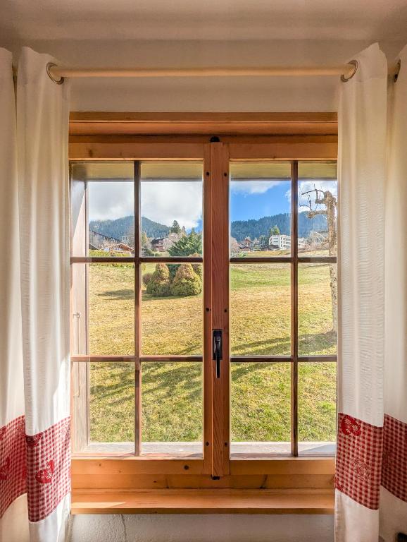 a window with a view of a field at Rare, quite & centered Apartment with Garden & Fireplace in Villars-sur-Ollon