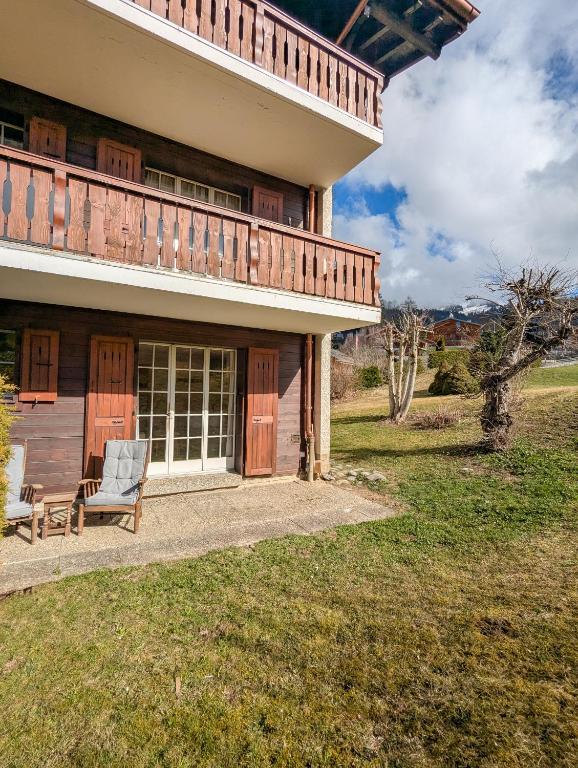 a house with a porch and a chair on a patio at Rare, quite & centered Apartment with Garden & Fireplace in Villars-sur-Ollon