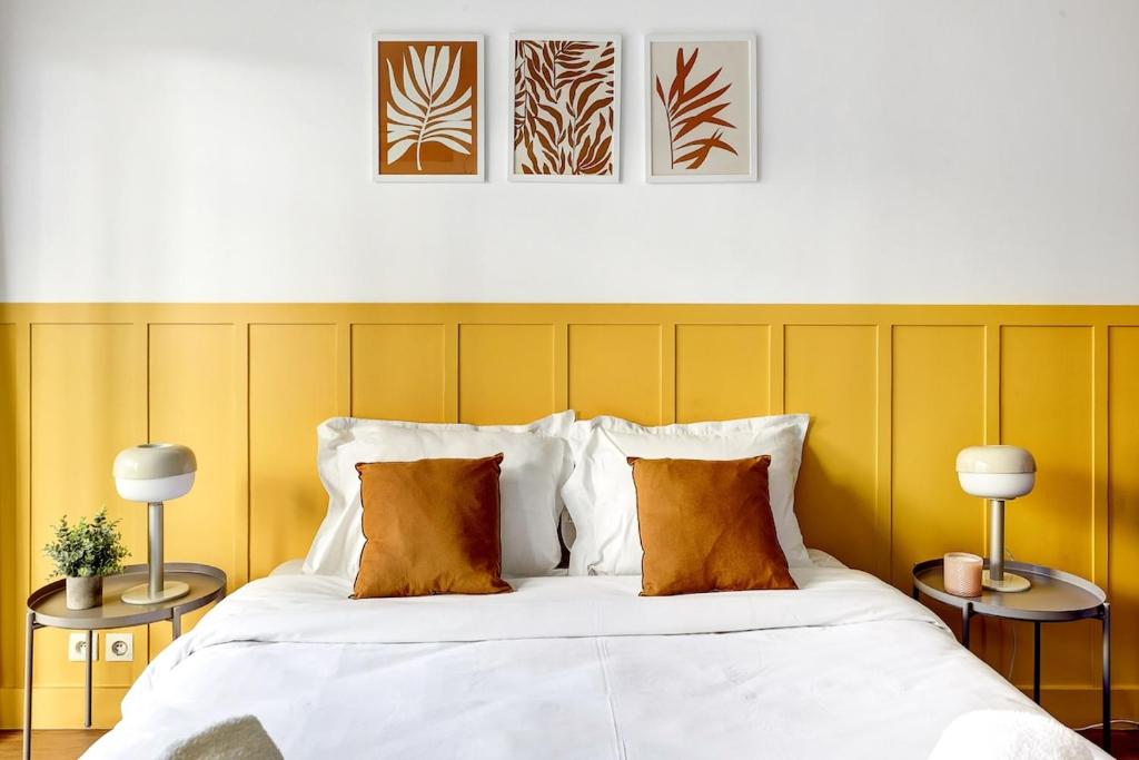 - une chambre avec un lit blanc aux murs jaunes dans l'établissement Eiffel residence Joséphine, à Paris
