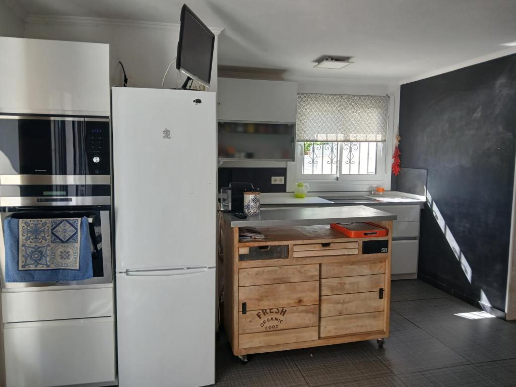 une cuisine avec un réfrigérateur blanc et un évier dans l'établissement Maison lumineuse et au calme, à La Celle-sous-Gouzon