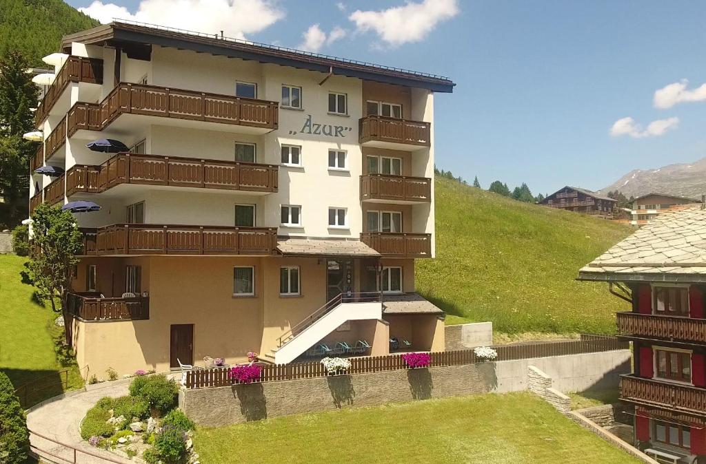a large apartment building with balconies on a hill at Apartment Azur in Saas-Fee