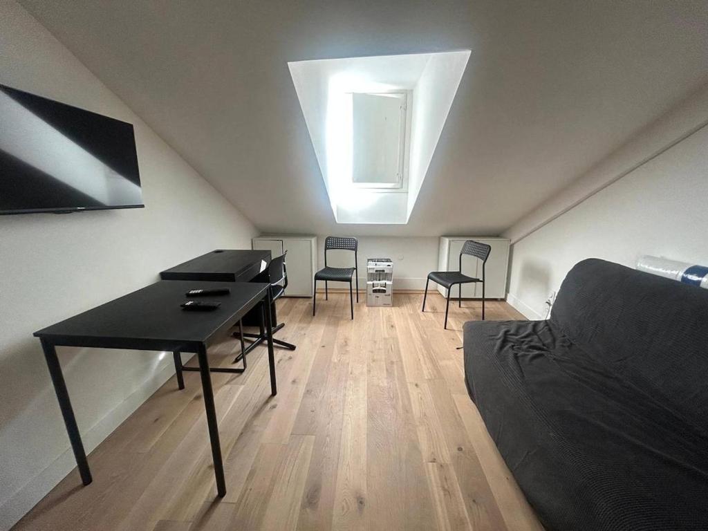 Cette chambre mansardée comprend un bureau et des chaises. dans l'établissement Nice Signature Assalit Studio, à Nice