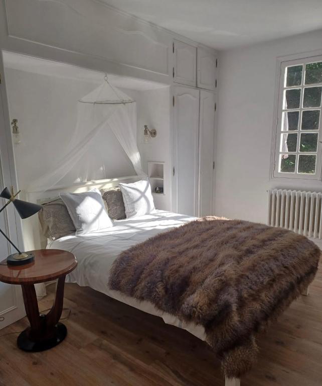 une chambre avec un grand lit avec une couverture marron dans l'établissement Castle like retreat next to the Dordogne River, à Argentat