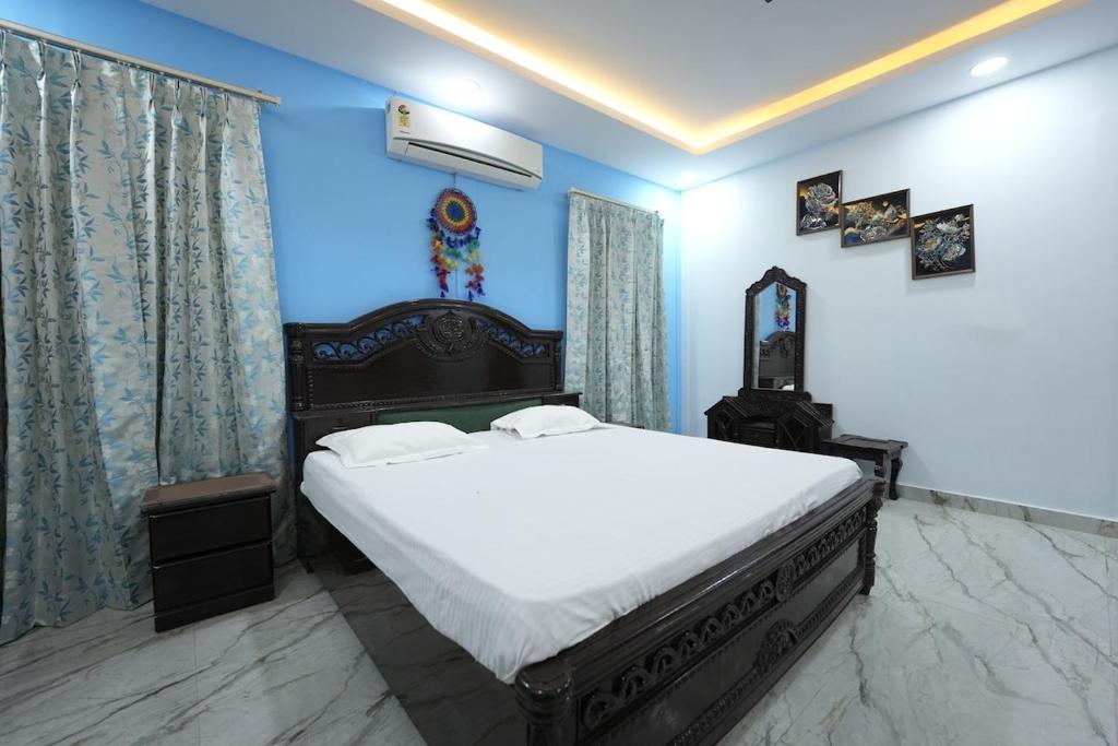 a bedroom with a large bed with blue walls at VanRaj Farm in Greater Noida