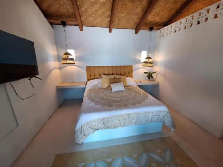 a bedroom with a bed and a flat screen tv at Casa Bonita in El Pescadero