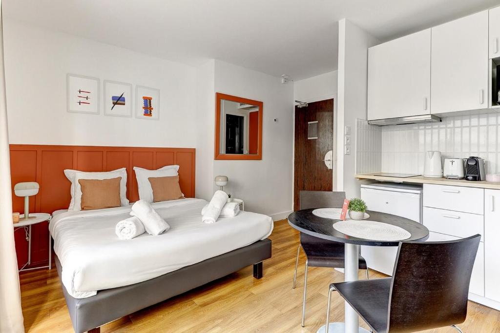 une chambre avec un lit et une table et une cuisine dans l'établissement Eiffel résidence Simone, à Paris