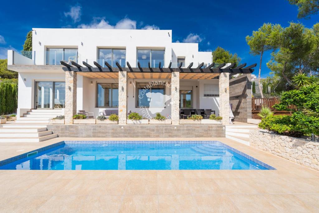 a villa with a swimming pool in front of a house at CostaBlancaDreams Casa con Vista in Calpe in Empedrola
