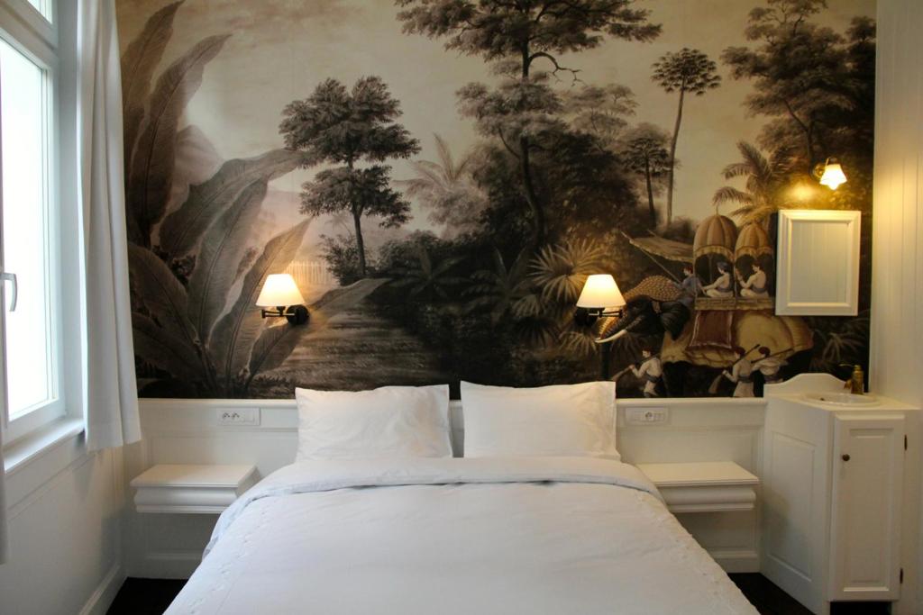 Un dormitorio con una pintura en la pared y una cama en L'Epicentre, en Bruselas