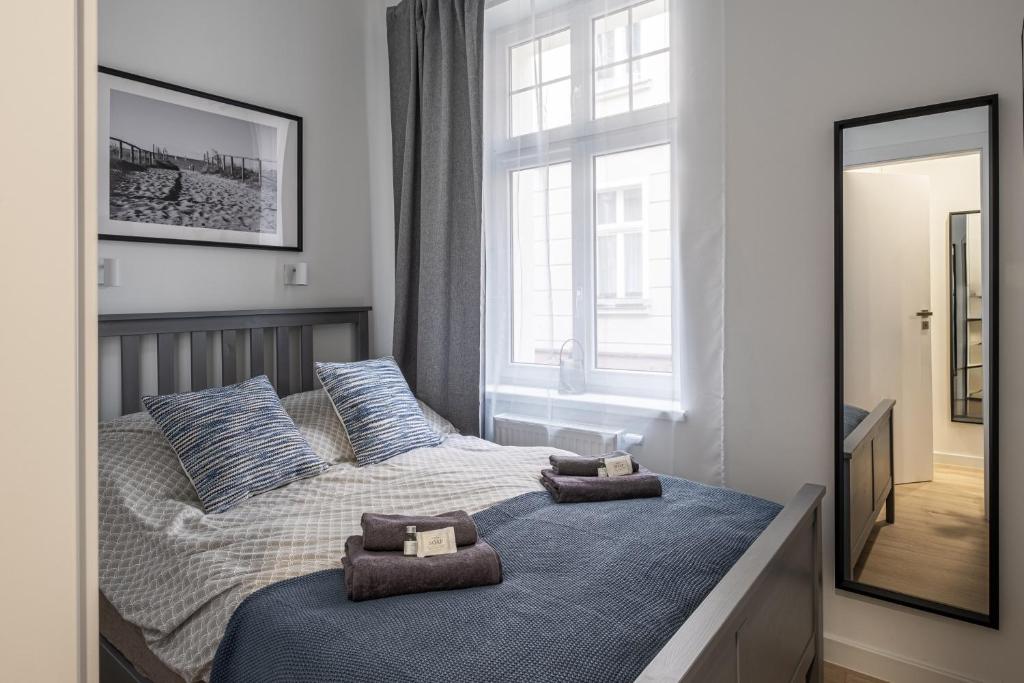 a bedroom with a bed with two towels on it at Monciak Comfort - Kamienica in Sopot