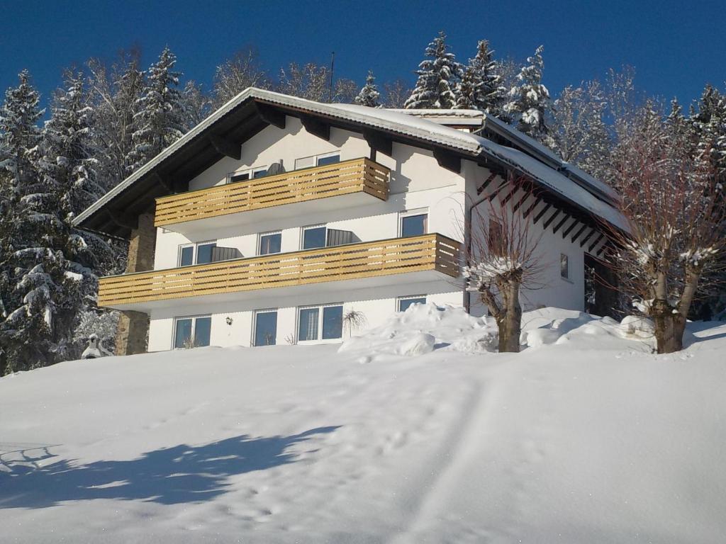 ein schneebedecktes Haus mit Balkon im Schnee in der Unterkunft Holiday Home Marianne by Interhome in Baierweg