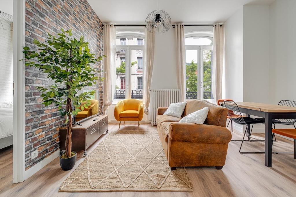 un salon avec un canapé et une table dans l'établissement Appartement spacieux et lumineux en plein centre, à Saint-Étienne