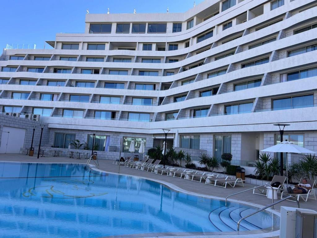 a large hotel with a swimming pool in front of a building at oR-Ya Suite in Eilat