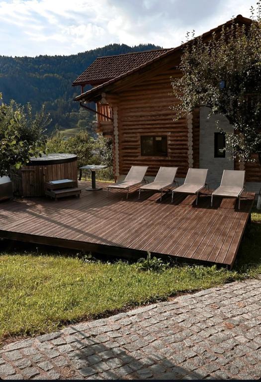 a wooden deck with chairs and a bench on a house at Cabana Livada in Borşa