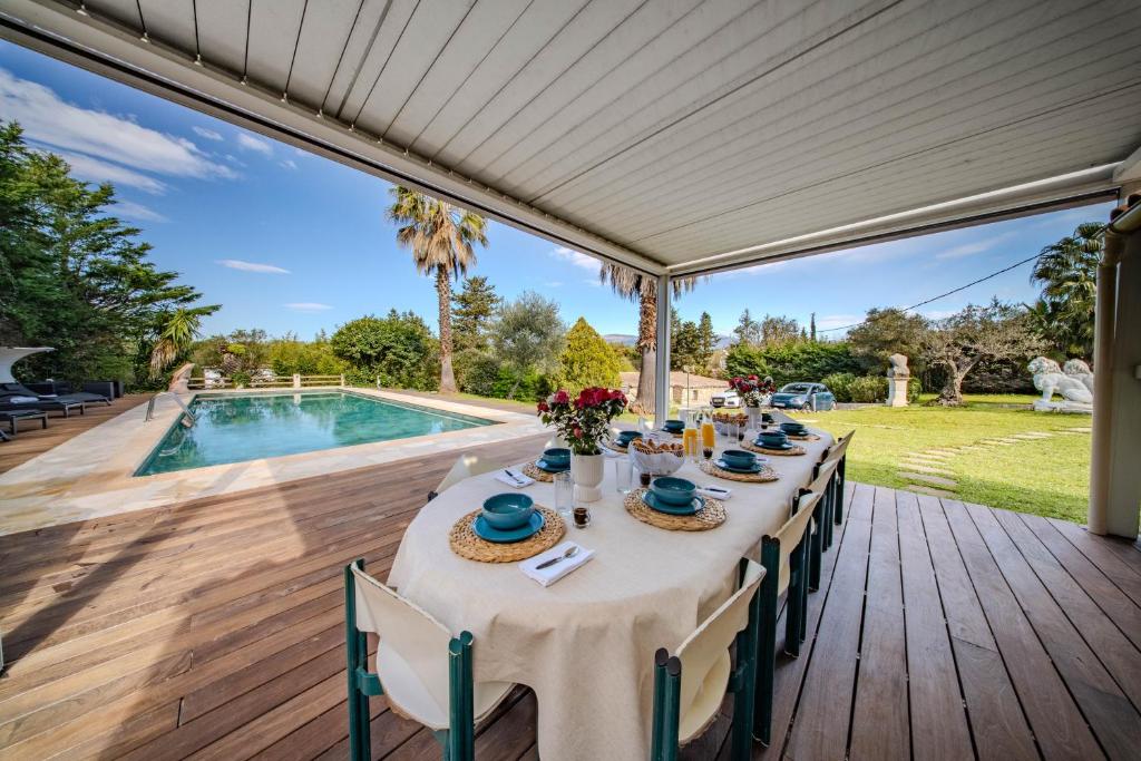 - une longue table sur une terrasse à côté de la piscine dans l'établissement Beautiful 300 m2 Villa, Big Pool, 3000m2 garden, à Mouans-Sartoux