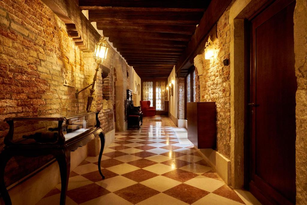 a hallway in an old building with a checkered floor at Nama Boutique Residence in Venice