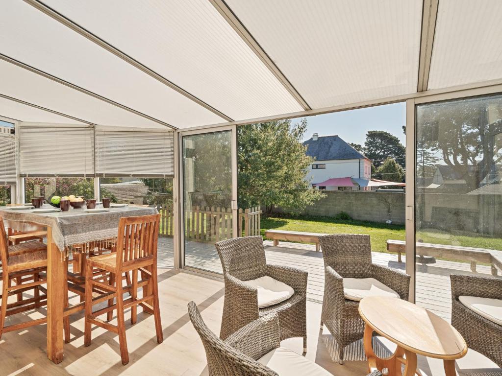 une véranda avec une table et des chaises ainsi qu'une terrasse dans l'établissement Holiday Home Terre Neuvas by Interhome, à Cancale
