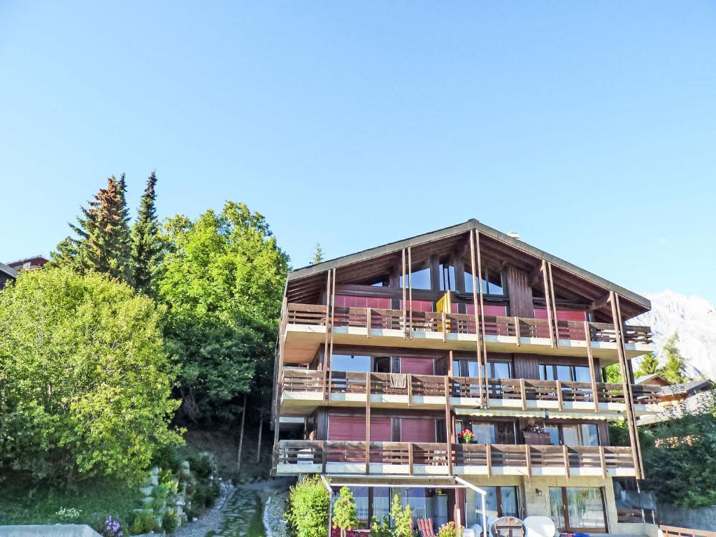 a building with balconies and a river in front of it at Apartment Austral 105 by Interhome in Ovronnaz