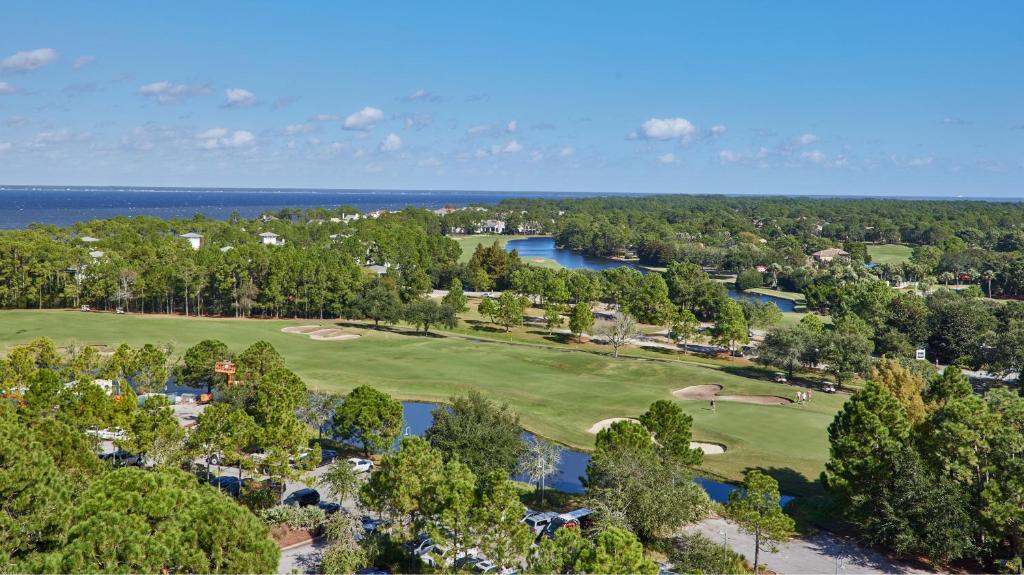 eine Aussicht über einen Golfplatz mit Bäumen und Wasser in der Unterkunft Hotel Effie Sandestin Resort, Autograph Collection in Destin