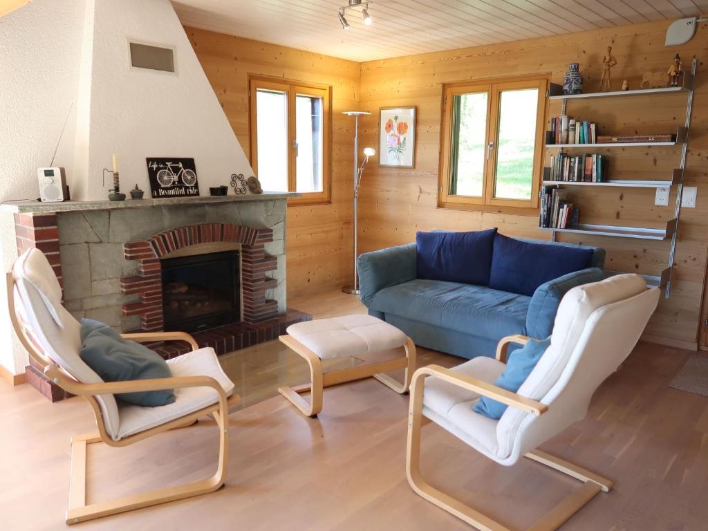 a living room with a couch and chairs and a fireplace at Chalet Sozi by Interhome in Le Châtelard-Montreux