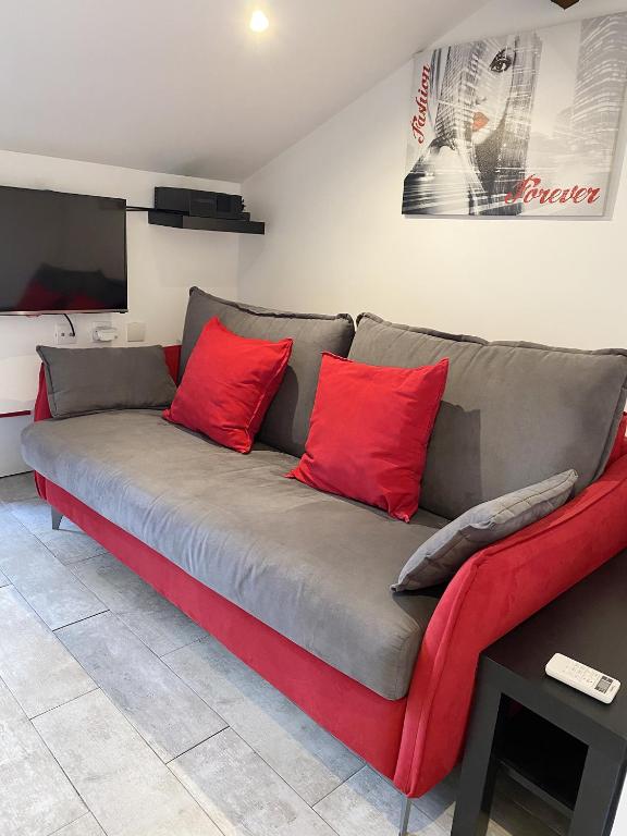 - un canapé avec des oreillers rouges dans le salon dans l'établissement Antibes Bis, à Cannes