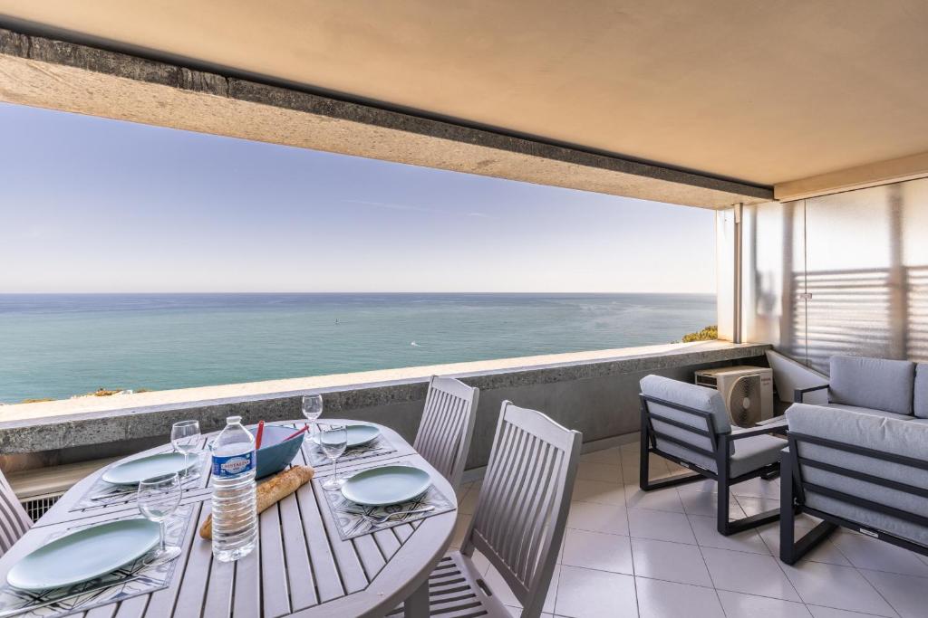 un tavolo e delle sedie su un balcone con vista sull'oceano di Costa Plana 135 a Cap d'Ail