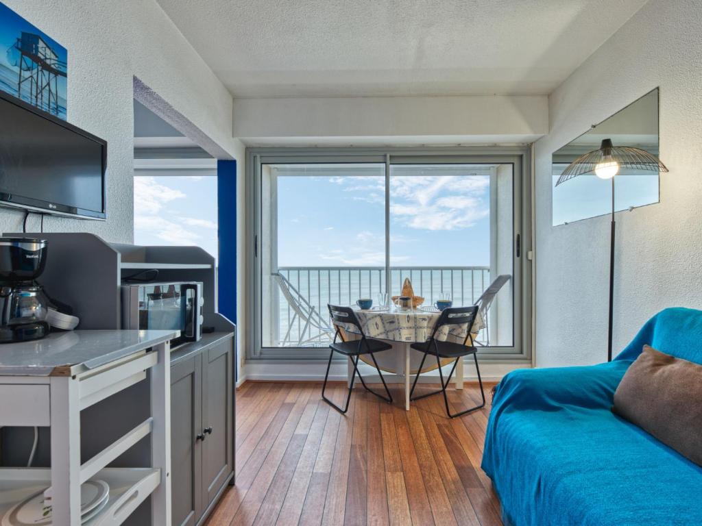 un salon avec un canapé bleu et une table dans l'établissement Apartment Les Sables d'Argent-11 by Interhome, à Lacanau