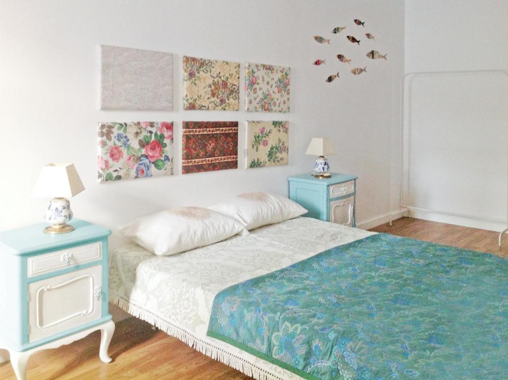 a bedroom with a bed with two night stands and two tables at O Sardinhas in Matosinhos