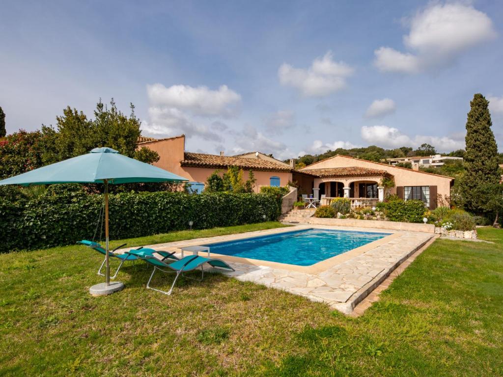 - une piscine avec un parasol bleu, une chaise et un parasol dans l'établissement Holiday Home Villa Philipp by Interhome, à Grimaud