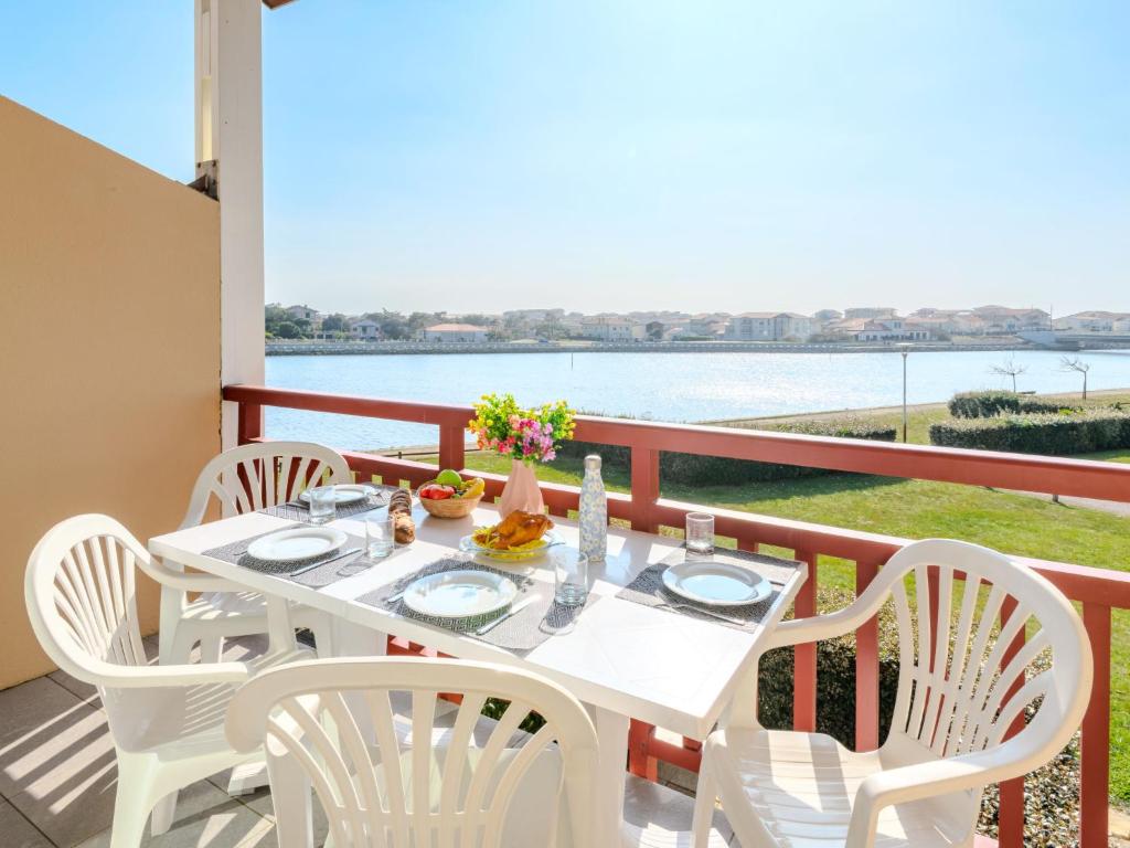 une table et des chaises sur un balcon avec vue sur l'eau dans l'établissement Apartment Les Pêcheurs-7 by Interhome, à Mimizan