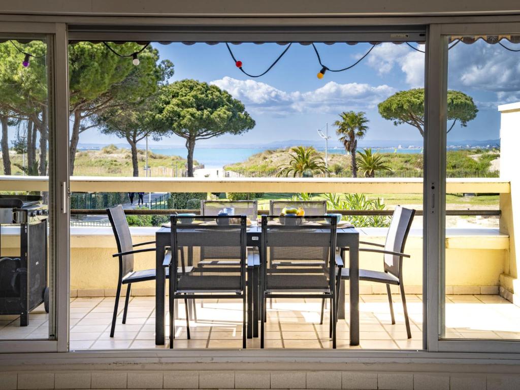 une table et des chaises sur un balcon avec vue sur l'océan dans l'établissement Apartment Le Serpent de Mer-8 by Interhome, au Grau-du-Roi