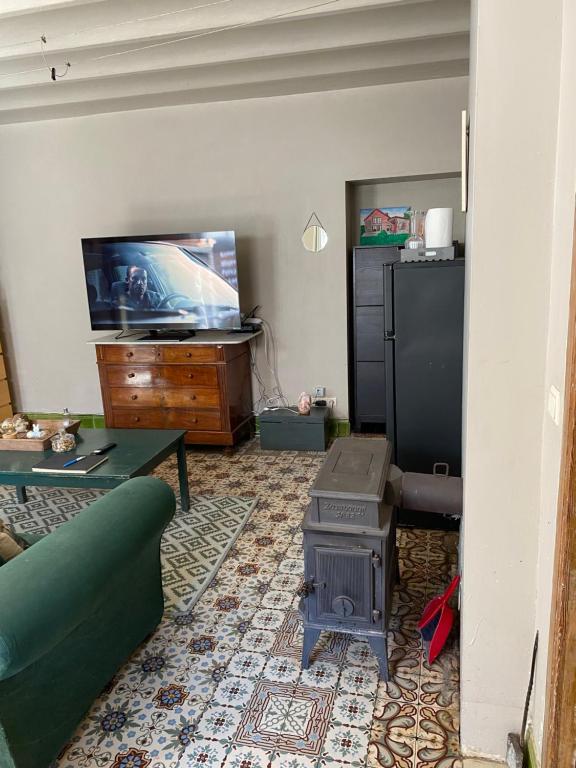 a living room with a couch and a stove at Chez Eloi in Tacfesse