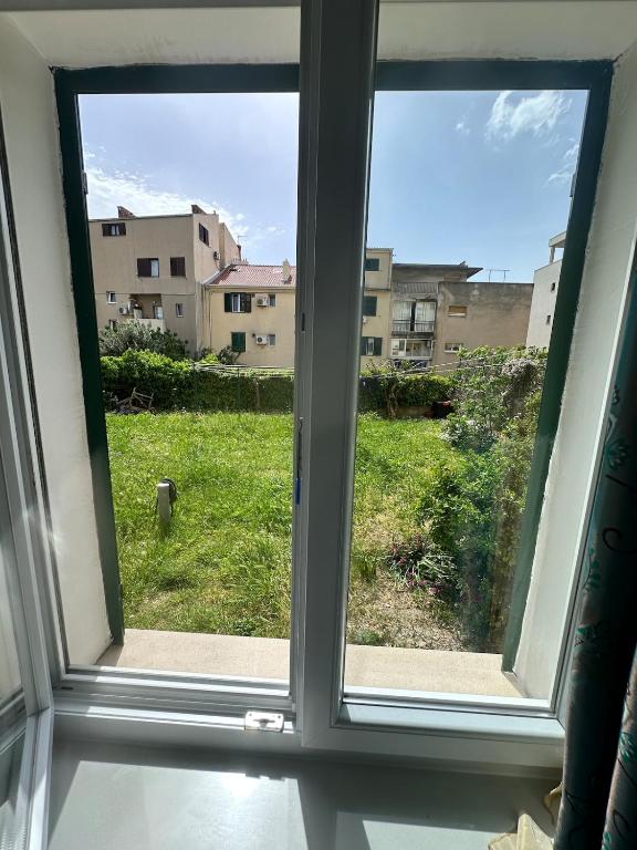 an open window with a view of a yard at Apartment DB in Split