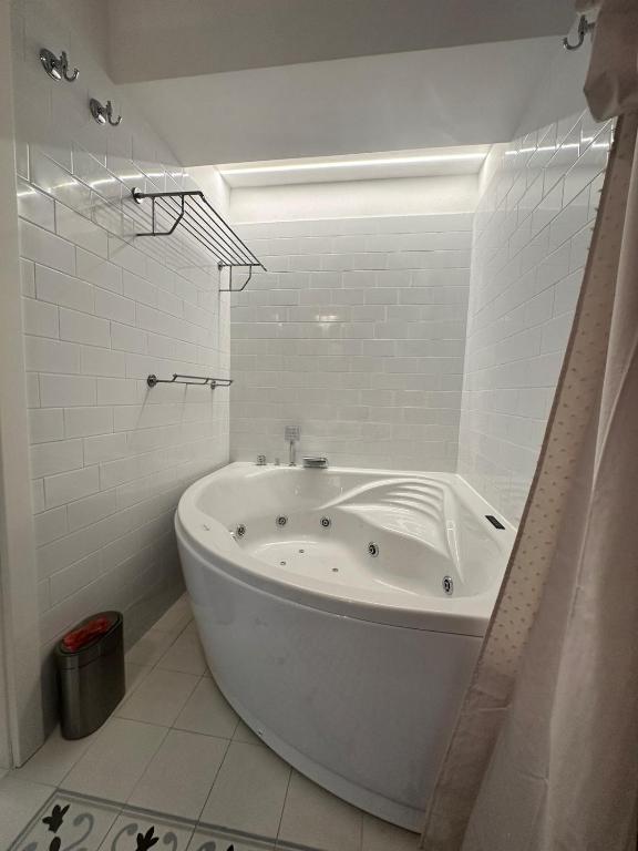 a white bathroom with a tub in a room at Apartment DB in Split