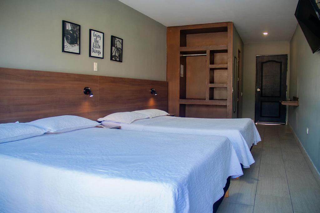 Postel nebo postele na pokoji v ubytování HOTEL MELGAR PLAZA