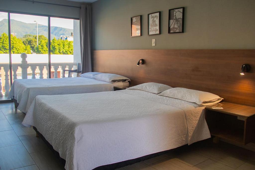 Postel nebo postele na pokoji v ubytování HOTEL MELGAR PLAZA