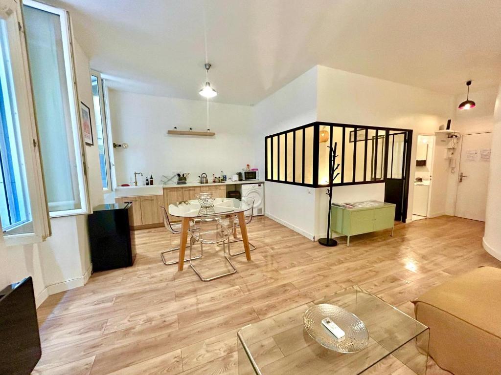 un salon avec une table et une cuisine dans l'établissement Chez Marie et Romain- appartement de charme au cœur de la Joliette proche Panier centre ville, à Marseille